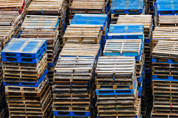 Empty shipping pallets stacked up after emptying their cargo.
