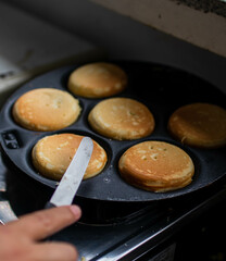 Making of home made pancakes on a black frying pan. Close up view