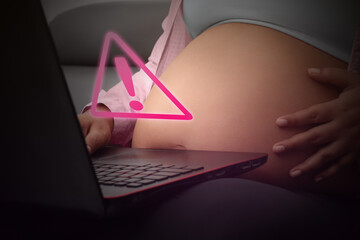 Concept pregnancy, pregnant woman receiving alert on laptop