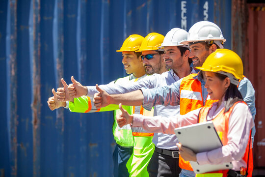 Group of workers and engineers with workers giving thumbs up in factory. Successful diverse teamwork standing in workplace.