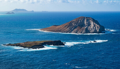 Mānana Island also known as rabbit island and Kāohikaipu Island also known as black rock in the foreground. In the background are the Mokulua Islands, the Mokumanu islands on Oahu Hawaii