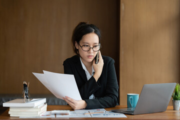 Image of Young woman with a cell phone working online on laptop computer. studying or working from home online concept.