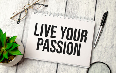 LIVE YOUR PASSION text on notepad with glasses, pen and calculator