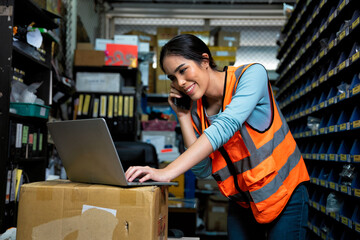 woman in storage room wearing  hi visible vest at work happy standing at office warehouse checking...