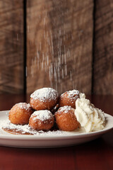 Beignet Donut Holes with powdered sugar and whipped cream