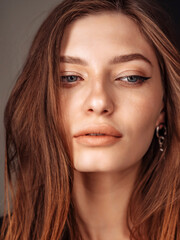 Obraz premium close-up face of a young woman with flawless skin, blue eyes, dark hair, beautiful lips, beautiful natural smile