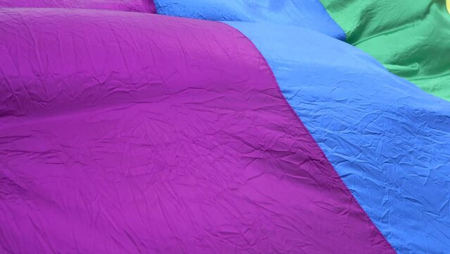 a gigantic 82 ft lgbt flag flutters in the air moving gracefully on a pride day where everyone goes out into the community to feel free
