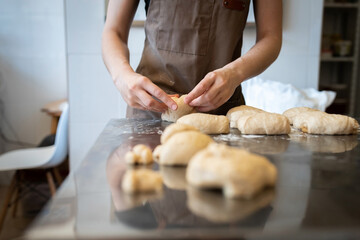 The process of making bread. Dividing the wheat dough into pieces for buns. Front view.