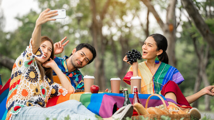 LGBTQ friends picnic. Happy young friends having picnic in theLGBTQ friends picnic. Happy young friends having picnic in the City Park.People hanging out fun,smiling and Selfie outside