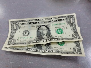 two one dollar united states of america bills on table - obrazy, fototapety, plakaty