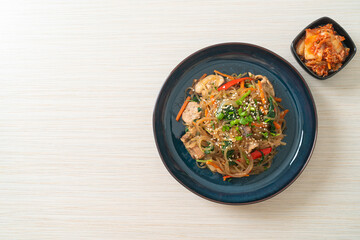 japchae or stir-fried Korean vermicelli noodles with vegetables and pork topped with white sesame