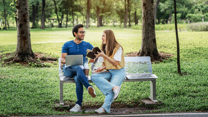 Partnership Student Friend holding Umbrella and working study with Partner support together at Park. Business young Couple Partner Discuss at the outdoor. Business Colleagues Outside Office. A Couple