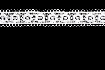 White lace with shape flowers on black background isolated horizontally