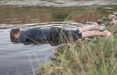 a corpse in the water, the body of a dead man was found by the lake near the pond, a drowned man...