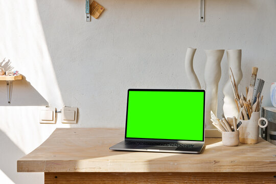 Workspace desk and laptop with green screen. Business image, Blank screen laptop and supplies.
