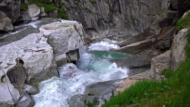 Beautiful waterfall cascade at famous Schöllenen Canyon, Canton Uri, on a sunny summer day. Slow motion movie shot July 3rd, 2022, Andermatt, Switzerland.