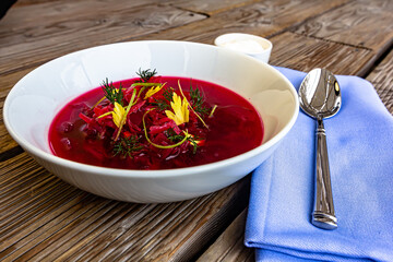 Vegetable cold soup with beet, cucumber, radsih and egg on wooden table