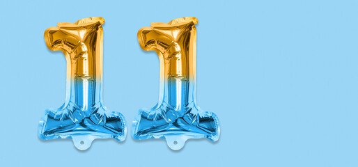 Rainbow foil balloon number, digit eleven on a blue background. Birthday greeting card with inscription 11. Top view. Numerical digit. Celebration event, template. Banner