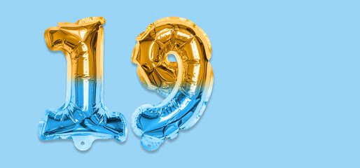 Rainbow foil balloon number, digit nineteen on a blue background. Birthday greeting card with inscription 19. Top view. Numerical digit. Celebration event, template. Banner