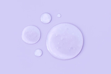 round drops of transparent gel serum on a pastel background