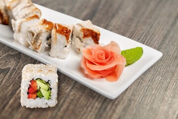 A set of fresh sushi rolls with salmon, avocado and sesame seeds served on a plate. Japanese sushi