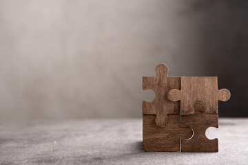 Creative idea and solve the problem concept. Teamwork success strategy - wooden puzzle on the grey...