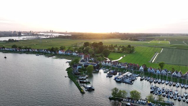 Durgerdam local dyke village with old traditional wooden houses in the north of Amsterdam. Harbour maritime countryside aerial landscape at sunset. Dutch Holland landscape.
