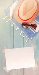 Summer Holiday Vacation Trip Mockup Concept Wallpaper with White Blank Free Space Paper Sheet with Adhesive Tape and Straw Hat Towel with Sunglasses and Protection Cream.
