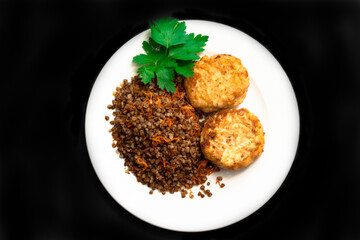 Healthy dinner. Top view, flat lay. Lunch bowl with buckwheat porridge, fried chicken cutlets . Black isolated background.