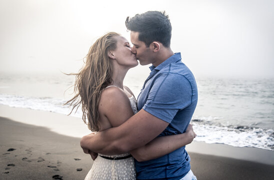 Couple portrait in a foggy day on the beach