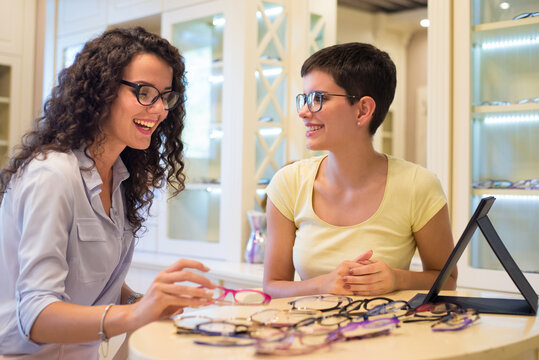 Young Beautiful Woman Choosing Eyeglasses In Optical Shop