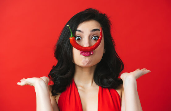 Image of beautiful woman having fun with a red chili pepper