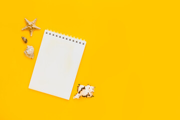 To do list or blank notebook with set of starfish, sea shell on yellow background. Travel, summer vacation or weekend, packing plan. lat lay, top view, copy space, place for text, minimal composition