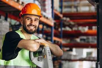 Workman at a factory standing by the pallet jack