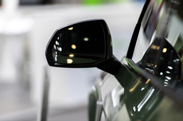 Side rear-view mirror on a modern car on blurred traffic background