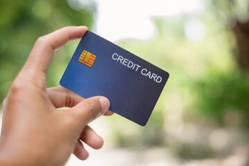 Credit Card. hand holding credit card with green nature background and copy space concept online...