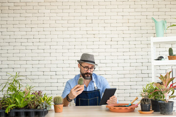 An elderly man handsome with have mustache wearing glasses is happy with tree care. is a hobby of gardening at home, living happily after retirement. Concepts nature and environment