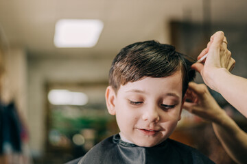 Haircut for little kid boy, professional barber doing haircut. Hairdress for children