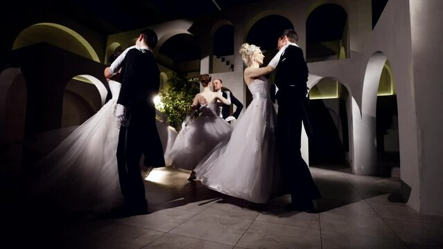 Performance of a romantic waltz dance at a medieval ball. In a tuxedo and a white long vintage dress. Background room in the old style