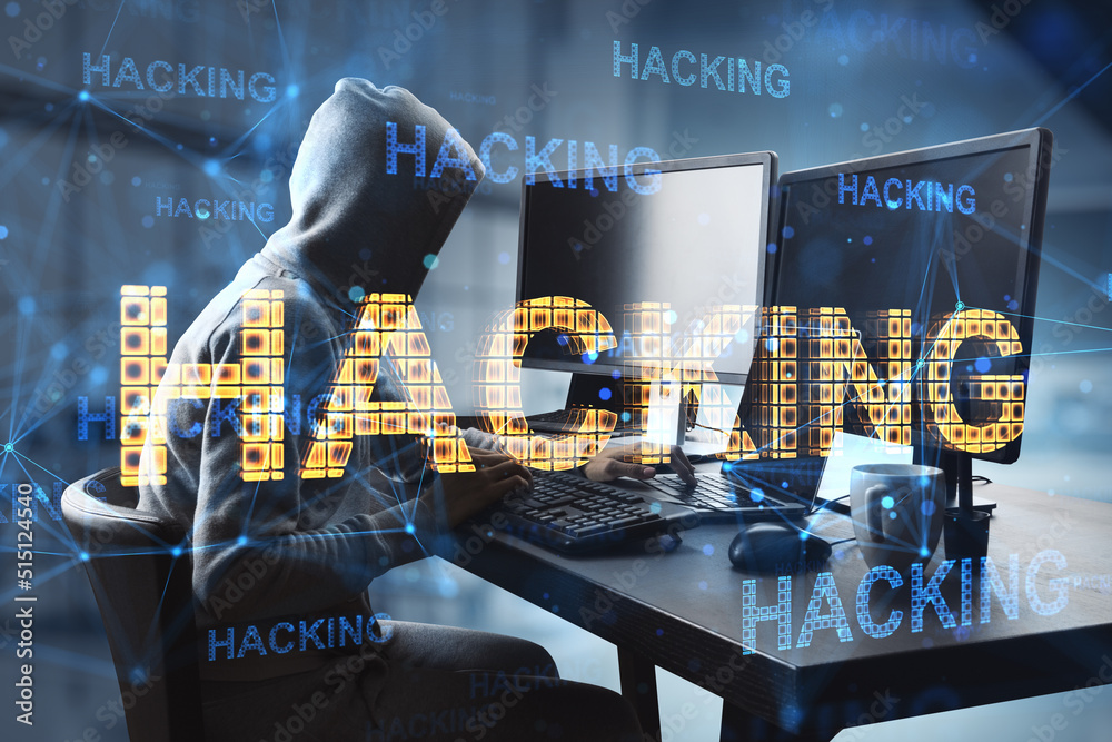 Poster Cyber attack and hacking concept with faceless hacker in hoody in front of computers and glowing digital yellow hacking word, double exposure