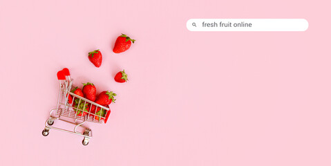 Fresh red strawberry in shopping cart on pink background. Online shopping and Valentines Day minimalistic concept. Black Fridays sales banner. Healthy, organic, vegan food © Lavsketch
