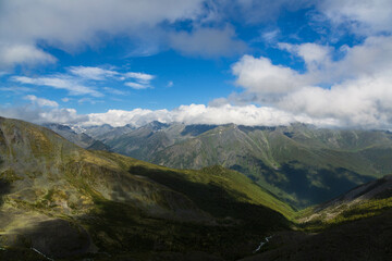 Aerial view over Altai mountains from Karaturek Pass on the way to Belukha mountain with blue sky with clouds. Altai region, Siberia, Russia