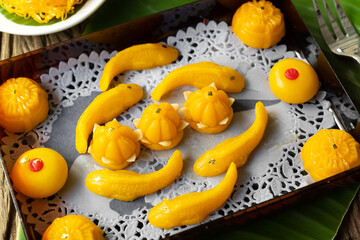 Thong-Eek, Sane Chan and Kanom Jamongkut (Thai sweets) in red box on wooden table