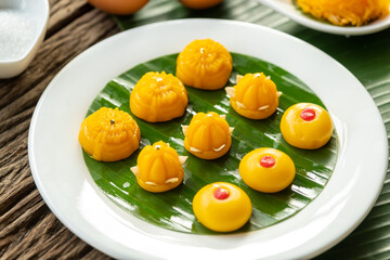 Thong-Eek, Sane Chan and Kanom Jamongkut (Thai Traditional dessert) on a white plate with banana leaves.