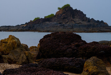 Fototapeta na wymiar Sharpe purple rocks at seashore