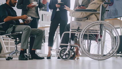 A disabled company employee is able to work happily with colleagues in the office.