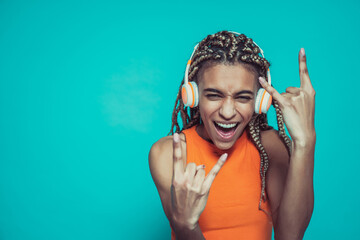 Beautiful girl with pigtails making party on a blue colored background