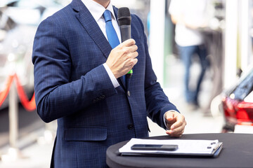Business person giving speech at opening ceremony or media event. Public speaking.
