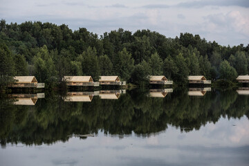 summer landscape with lake green forest and glampings around the lake