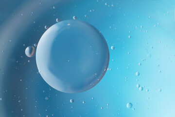 abstract light blue background with oil circles . bubbles of water close up .